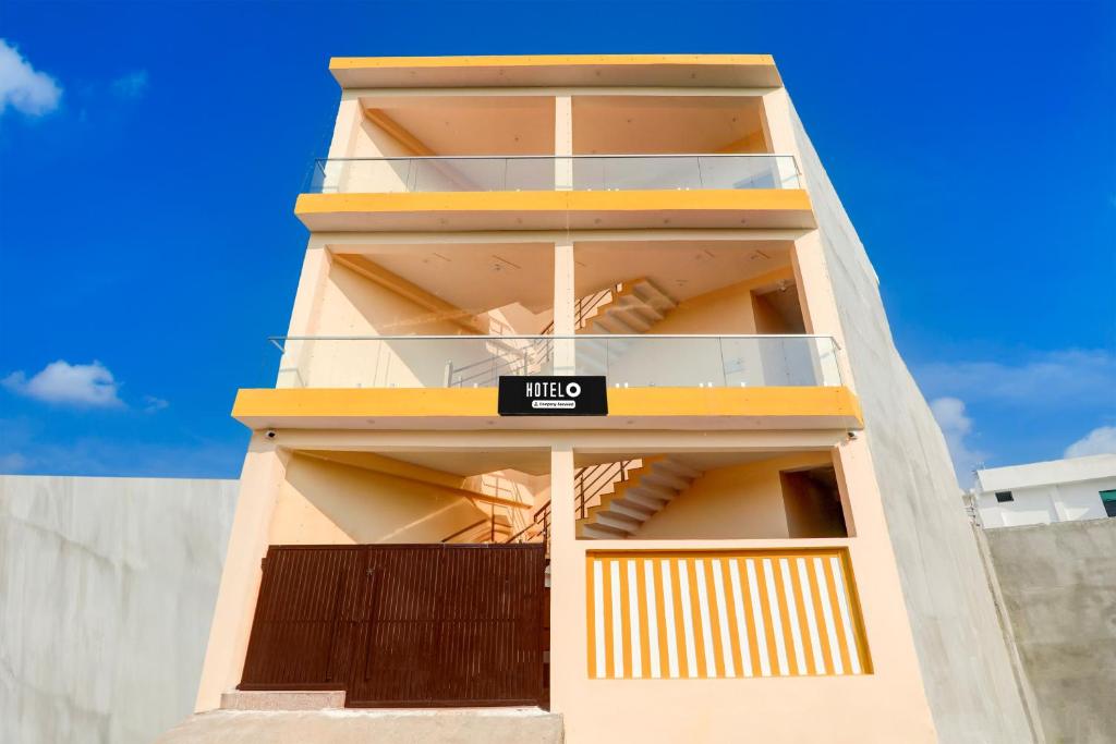 a tall yellow building with a sign on it at OYO Hotel O Arjun Ganj in Lucknow