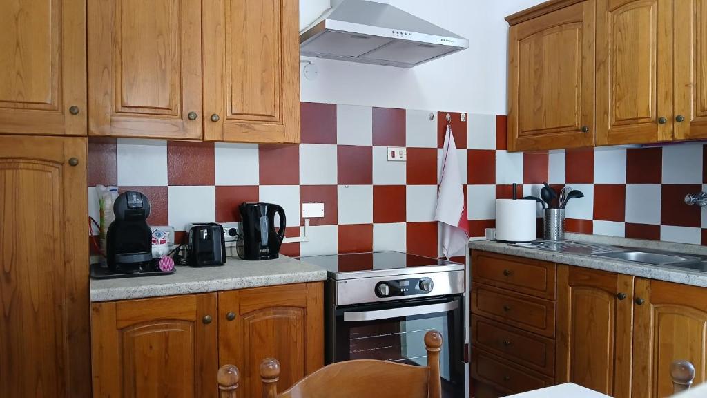 a kitchen with red and white checkered wall at Casa storica di Sant'Andrea by Italita in Calamandrana