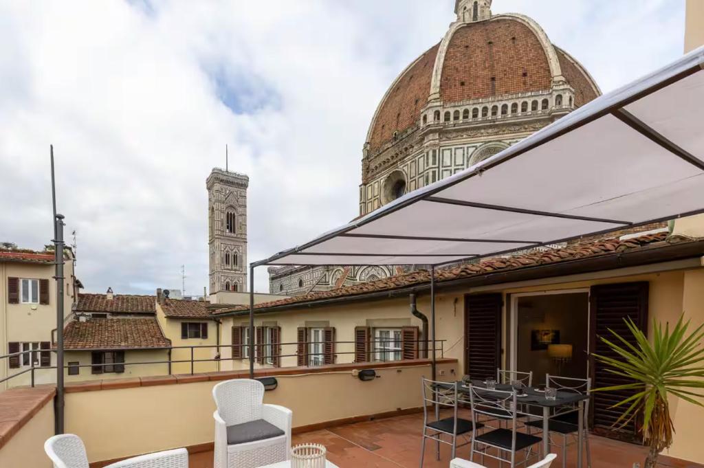 a balcony with a table and chairs and a clock tower at Pallottole Duomo Apartments in Florence