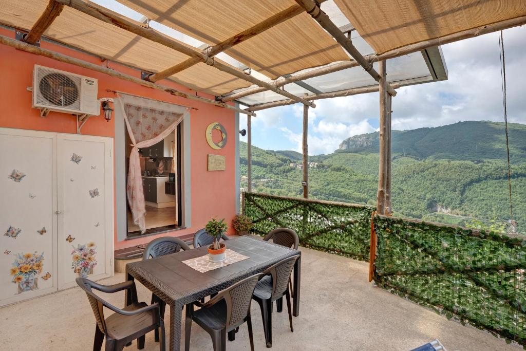 a dining room with a table and chairs on a balcony at Prima Luce in Vico Equense