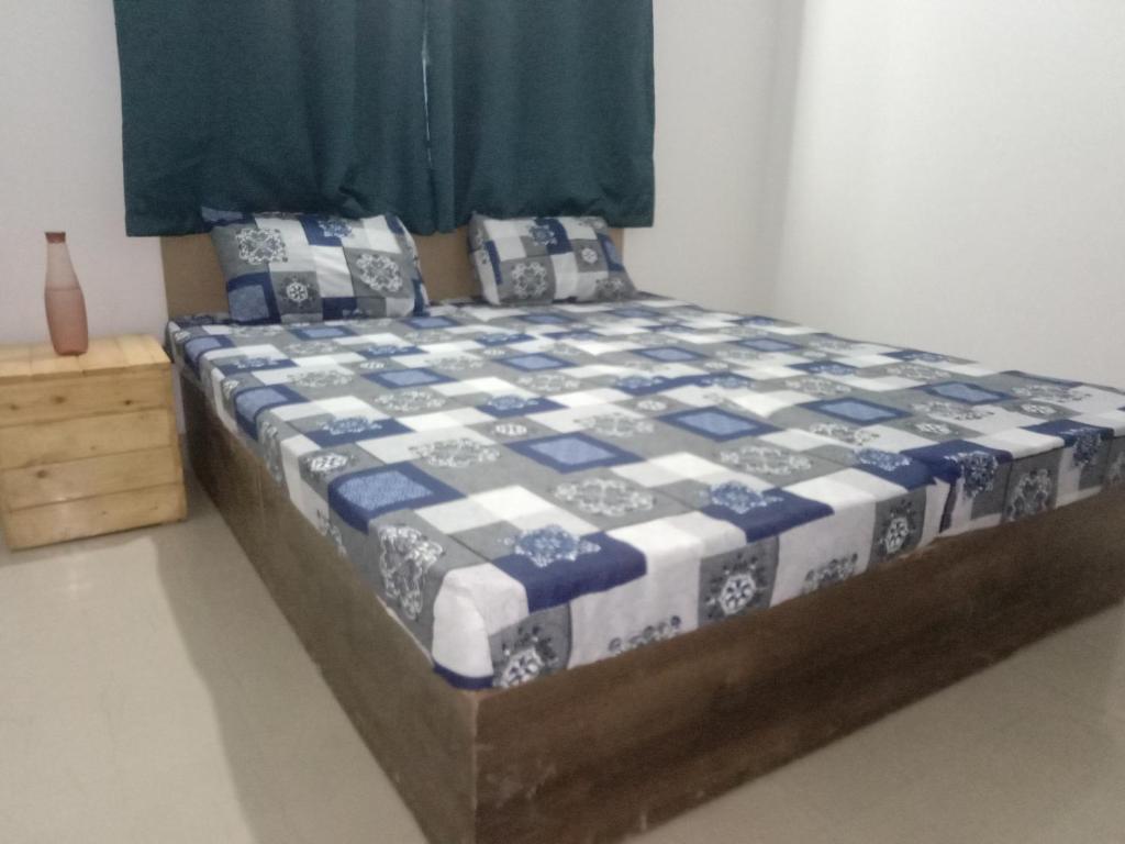 a bedroom with a bed with a blue and white quilt at Family Room in Indore