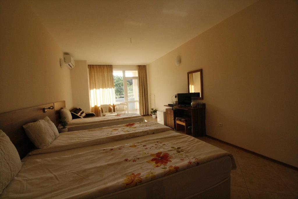 a hotel room with two beds and a television at Hotel Marant in Sozopol