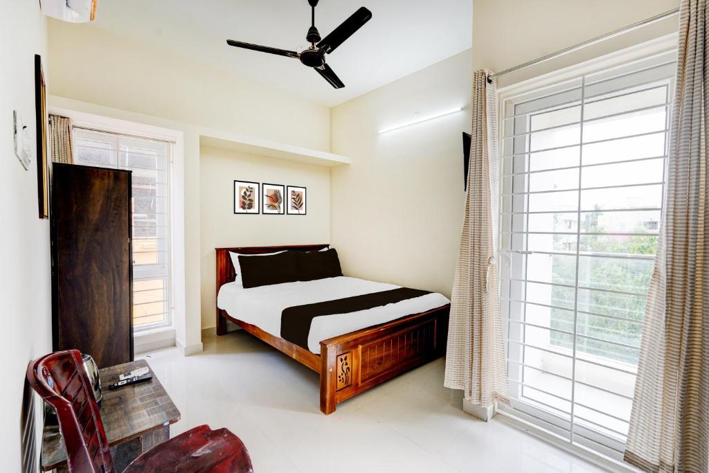 ein Schlafzimmer mit einem Bett und einem großen Fenster in der Unterkunft Super Collection O Sholinganallur Chennai Formerly Nimalan Residenc in Chennai