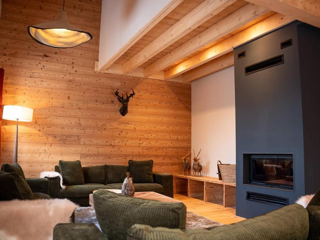 ein Wohnzimmer mit Sofa und Fernseher in der Unterkunft Chalet familial à Valmorel pour 24 personnes avec sauna et grandes terrasses - FR-1-291-1009 in Les Avanchers