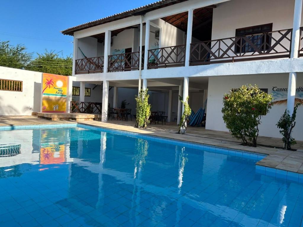 ein Hotel mit einem Swimmingpool vor einem Gebäude in der Unterkunft Pousada Marazul in Caucaia