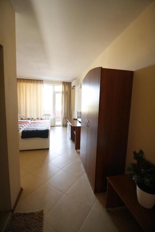 a hotel room with a bedroom with a bed at Hotel Marant in Sozopol