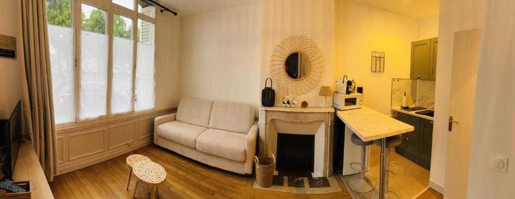 a living room with a couch and a table at Cozy studio en centre ville in Beauvais