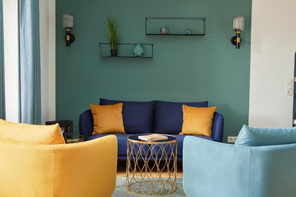 a living room with a blue couch and two chairs at Pidder-Lyng Apartment 11 in Böhl