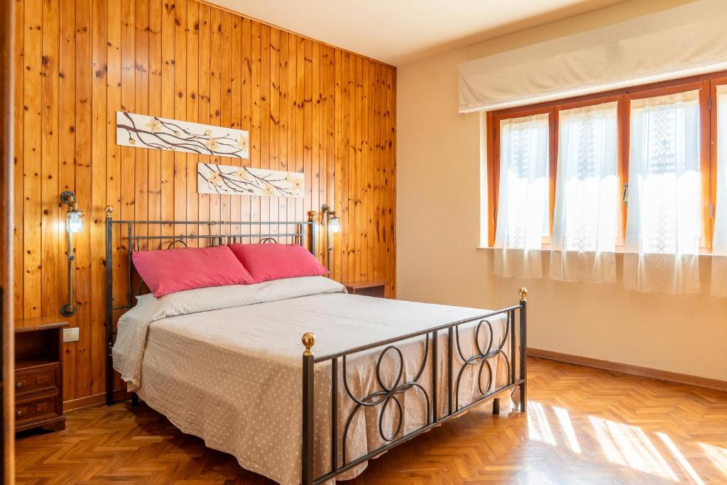 Un dormitorio con una cama y paredes de madera. en Casa Vacanza Lola, en Castiglion Fiorentino