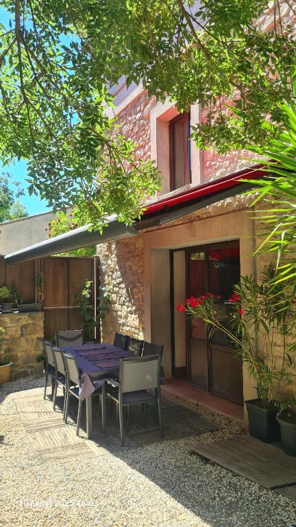 une table et des chaises assises à l'extérieur d'un bâtiment dans l'établissement Villa Misanid écrin de verdure à 15mm de la cité de Carcassonne, à Mas-des-Cours
