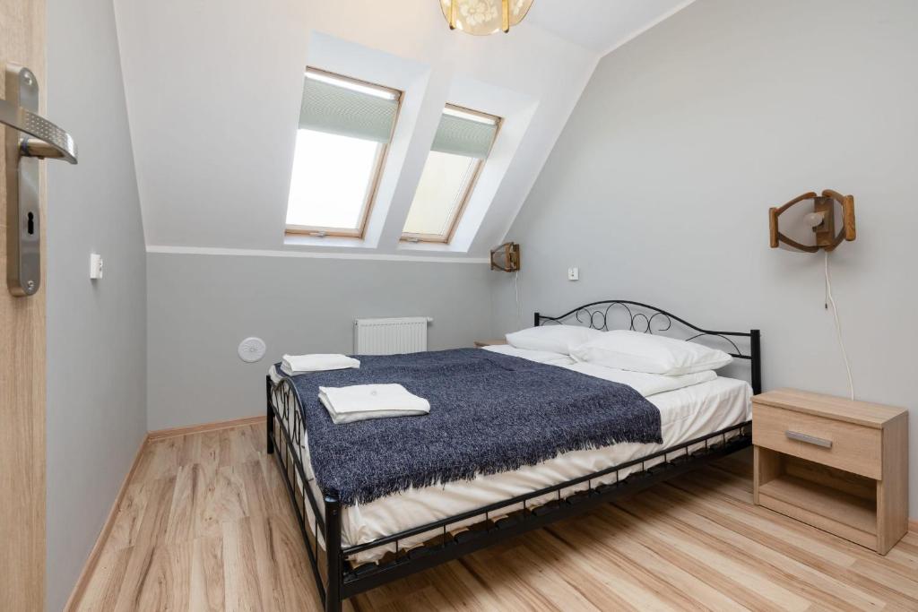 a bedroom with a bed and two windows at Peaceful Apartment Wrzosowo Bay with Parking by Noclegi Renters in Wrzosowo