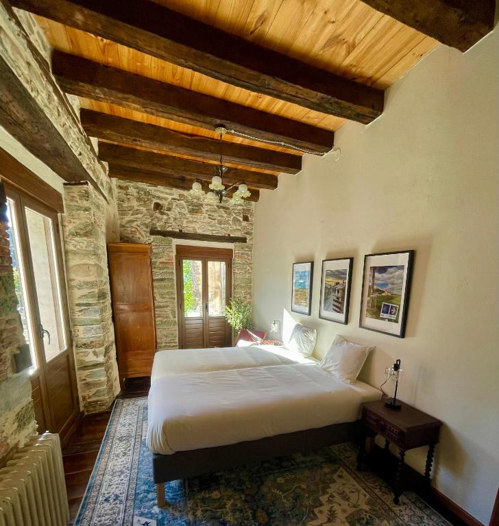 a bedroom with a large bed in a stone building at Casa El Colibrí in Villafranca del Bierzo