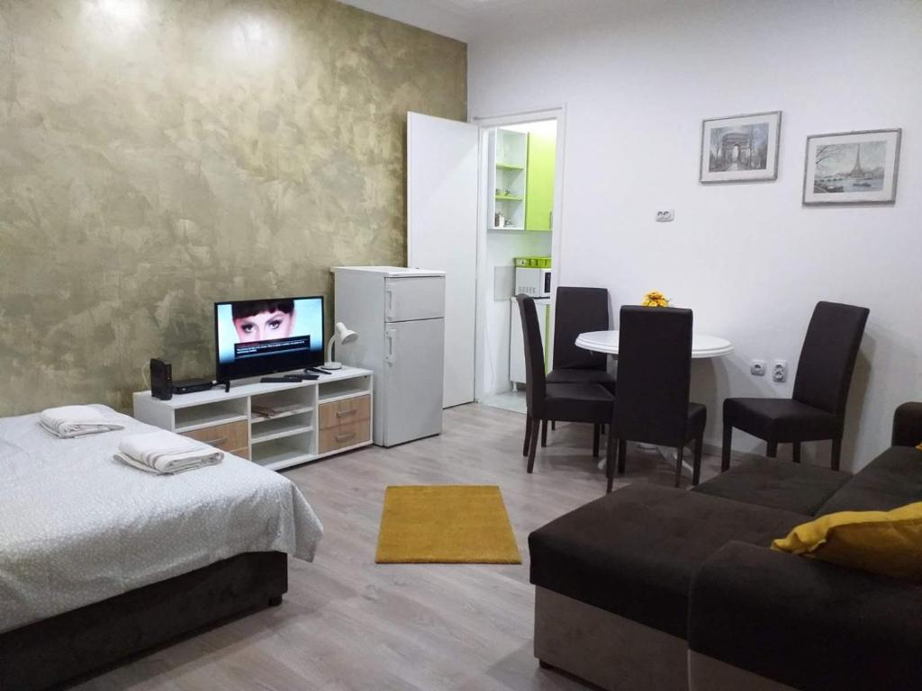 a living room with a bed and a table with a tv at Belvedere Skadarska Apartment in Belgrade