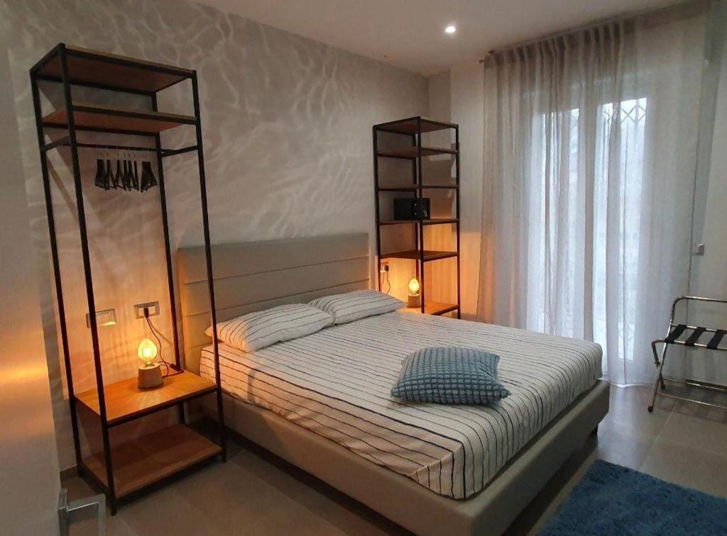 ガビッチェ・マーレにあるPlaya-degli-Angeli-GRECALEのベッドルーム1室(大型ベッド1台、棚2つ付)