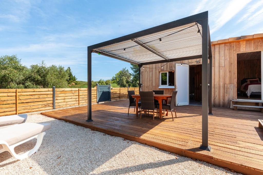 a wooden deck with a table and chairs on it at Le Chalet Des Oliviers in Roquefort-la-Bédoule