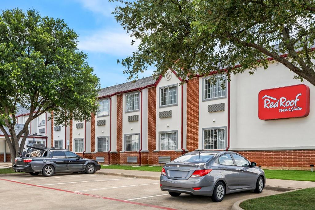 尤利斯Red Roof Inn & Suites Euless - DFW Airport Southwest的两辆汽车停在红岩旅馆前的停车场