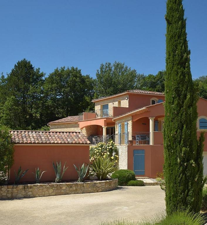 a large orange house with a tree in front of it at Le Mas du Grand Chêne - Chambres & Roulotte in Nyons