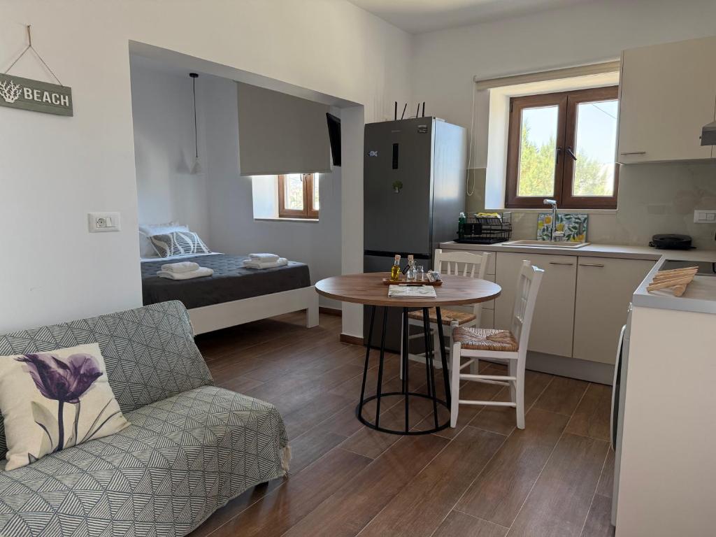 a living room and kitchen with a couch and a table at Kalithea Chorio 2 in Angathiás