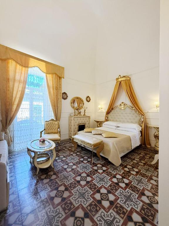 a bedroom with a king sized bed and a table at DONNA LUCREZIA b&b Boutique Hotel Style - RELAX & BUSINESS STAY in Bisceglie