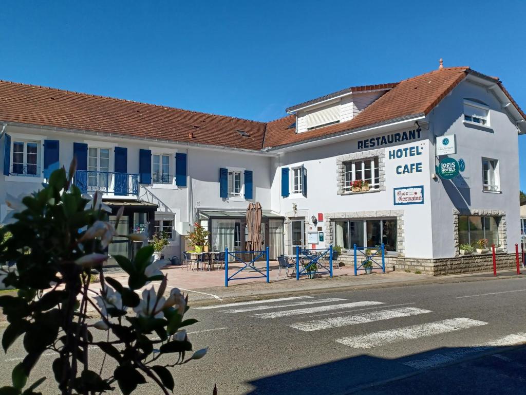 a large white building with a hotel cafe on the street at Logis Chez Germaine in Geüs-d'Oloron