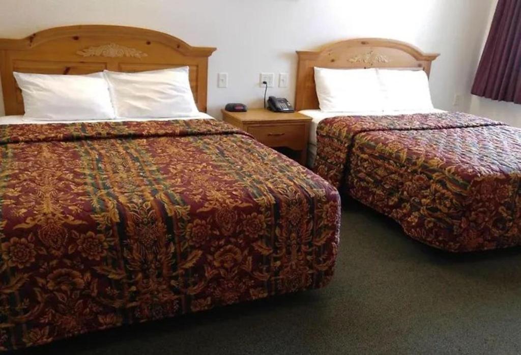 two beds in a hotel room with two beds at Guardian Inn in Le Center