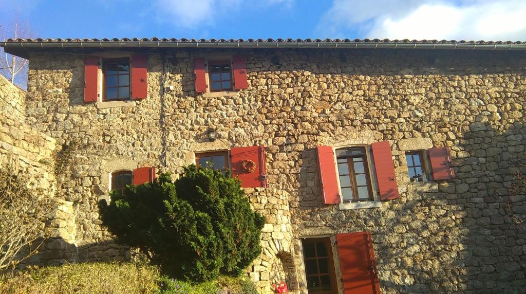ein Steingebäude mit roten Fensterläden darauf in der Unterkunft L'Oustau de Pequeti in Laboule