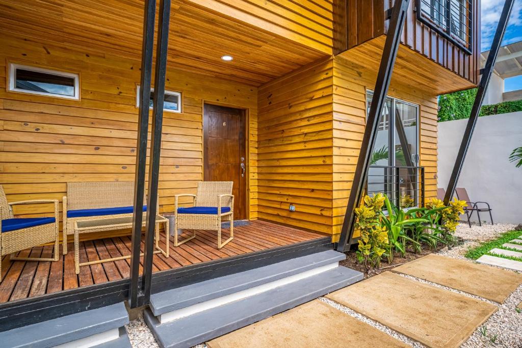 a wooden deck with two chairs and a table at Macondo Ecolodge Alpinias - Veranera in Coco