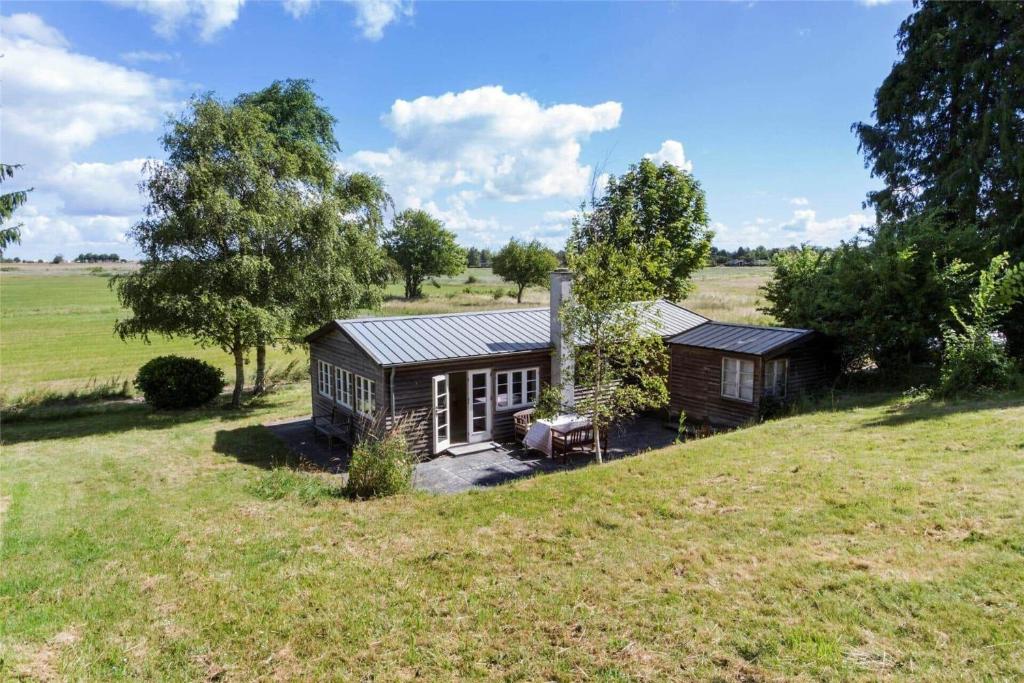 a small house in a field with trees and grass at 1035-Stege-Teglvaerksvej-39 in Stege