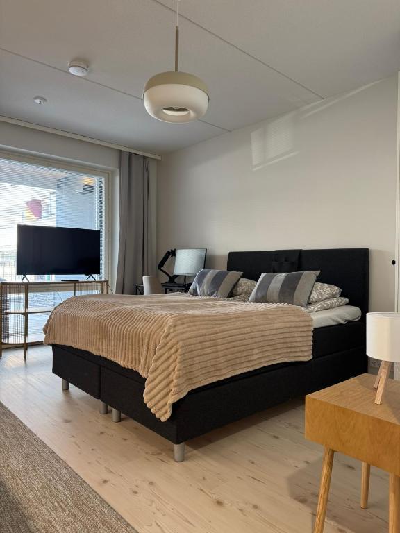 ein Schlafzimmer mit großem Bett und Fernseher in der Unterkunft Pramea Apartments Aallonharja 6 in Jyväskylä