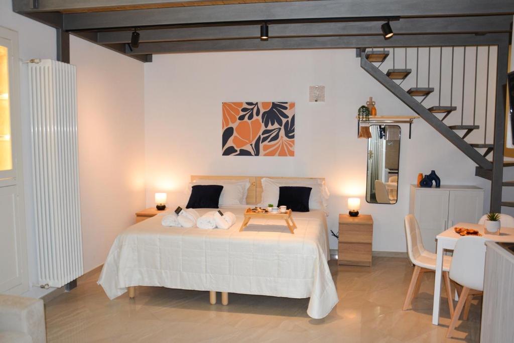 a bedroom with a white bed and a table at Carpe Diem Matera in Matera