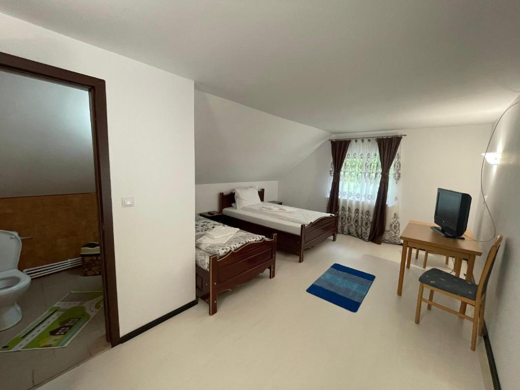 a bedroom with a bed and a bathroom with a mirror at Pensiunea Pe drumuri de munte in Borca
