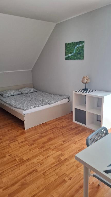 a bedroom with a bed and a table and chairs at Kapitan Hook - Pokoje Miejsce na ROWERY in Władysławowo