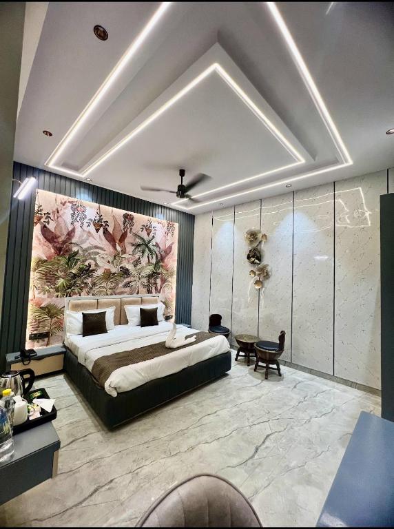a bedroom with a large bed and a large mural at Hotel Chelsea Plaza in Alīgarh