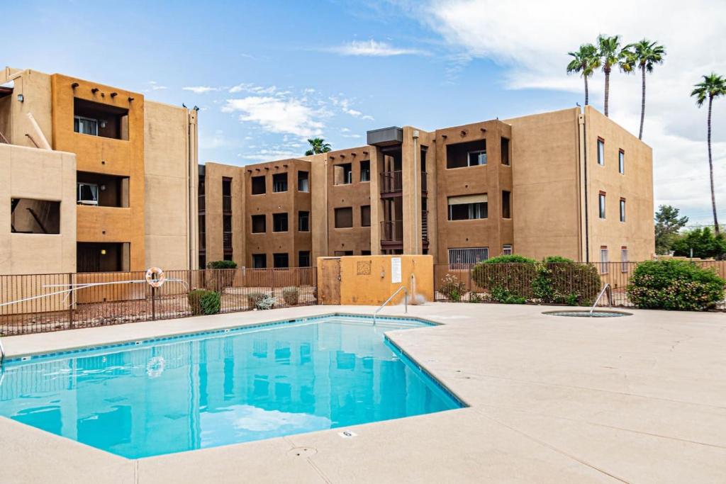 een zwembad voor een gebouw met palmbomen bij Casa Club Condo in Tucson