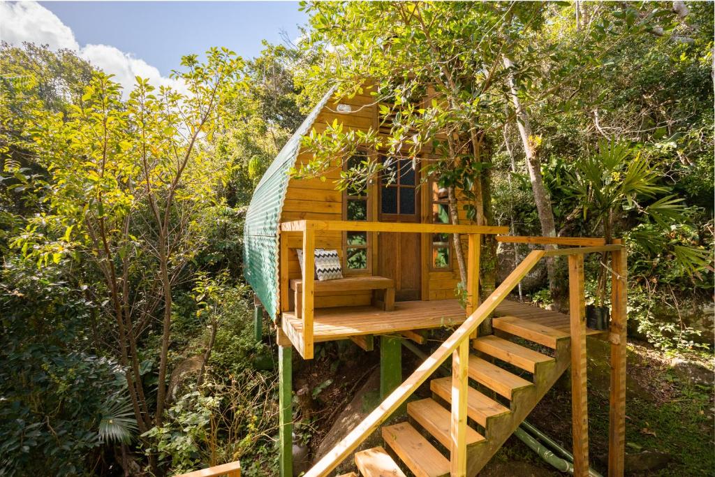 a tree house with a swing in the woods at Micro Casa Gótica in Florianópolis