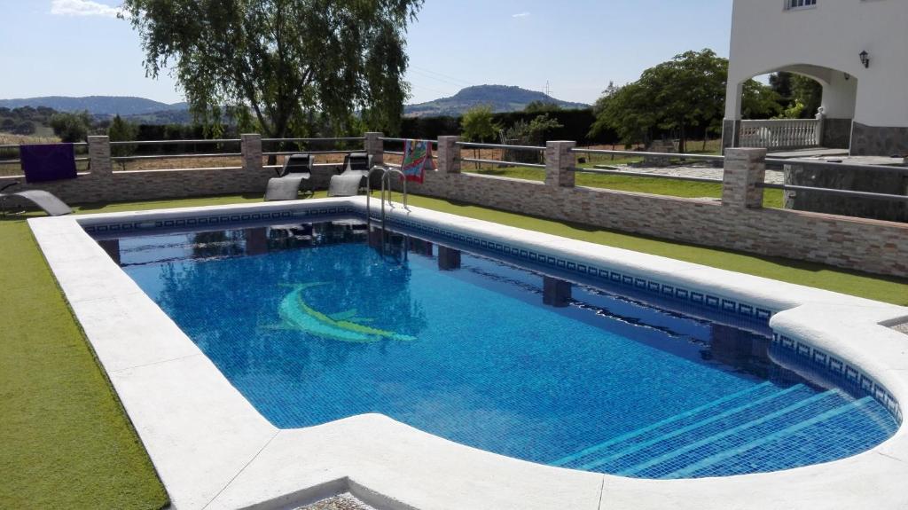 a swimming pool with blue water in a yard at Casa Rural Entreparques in El Bosque