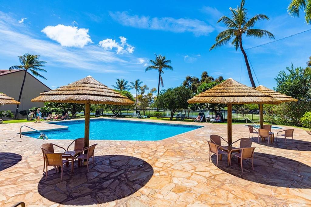 una piscina con sillas y sombrillas en Kaanapali Royal Q-202, en Lahaina
