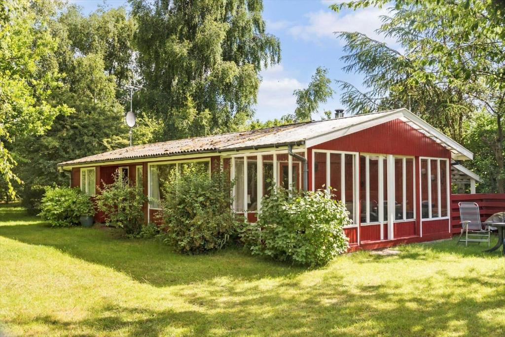 a red house in a field with a yard at 5011-Askeby-Faergensvaenge-17 in Askeby