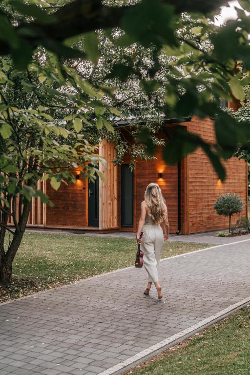 a woman walking down a brick sidewalk at Przystanek Roztocze- leśne SPA, Jacuzzi & sauna in Susiec