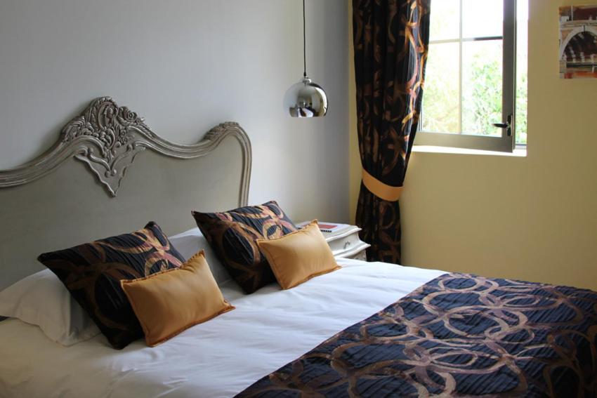 a bedroom with a bed with pillows and a window at Villa Toscane 2 in Marciac