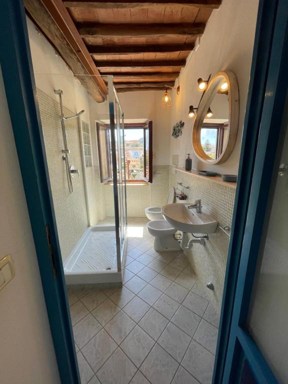 un bagno con doccia, WC e lavandino di bilocale in centro a capoliveri a Capoliveri