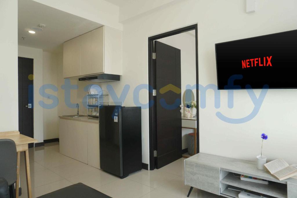 a kitchen with a refrigerator and a tv on a wall at 1BR Citra Plaza Nagoya A2812 City and Sea View in Jodoh