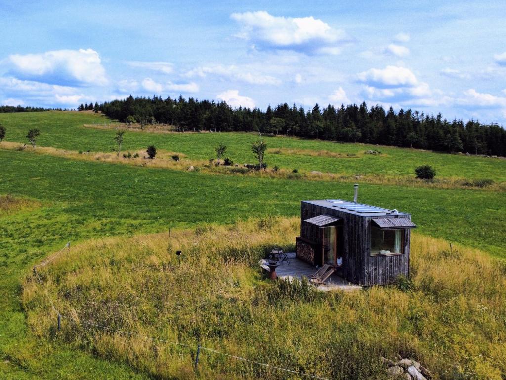 an out house sitting in a field of grass at Glamping Na Malém Háji in Hora Svaté Kateřiny