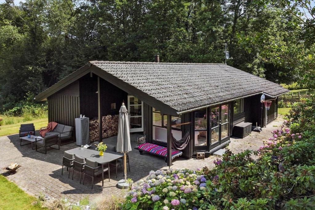 a small cabin with a table and chairs in a garden at 3077-Stege-Bundgarnet-137-B in Stege