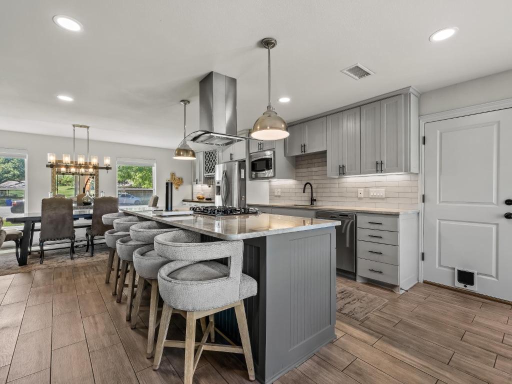 a kitchen with a large island with bar stools at Farmers Branch 10th Tee Golf Retreat in Farmers Branch
