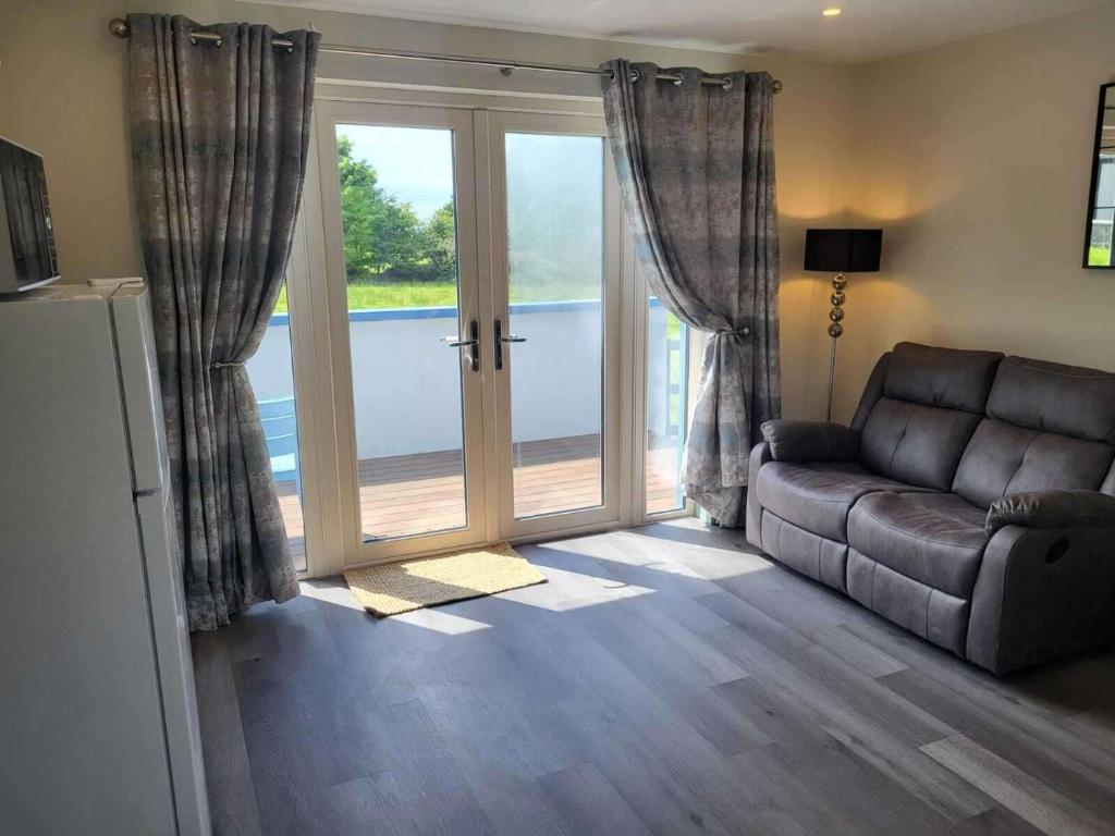 a living room with a couch and a sliding glass door at Apartment- Kilglass- Enniscrone- Pet Friendly in Sligo