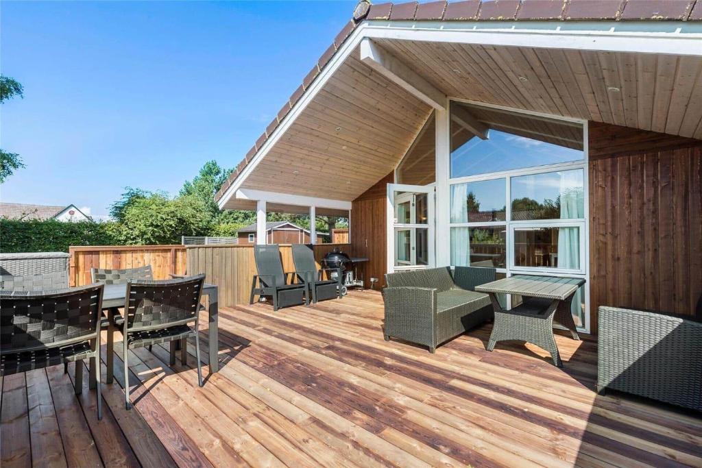 una terrazza in legno con sedie, tavolo e griglia di 3307-Stege-Maegleren-7 a Stege