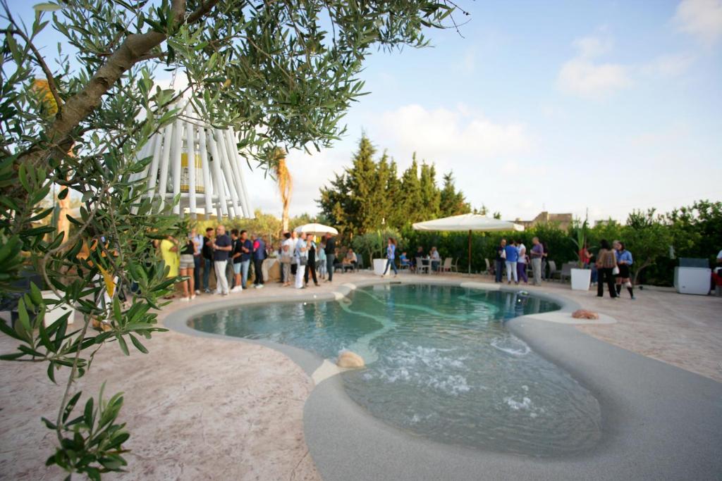 a swimming pool with people standing around it at diVino Hotel in Rilievo