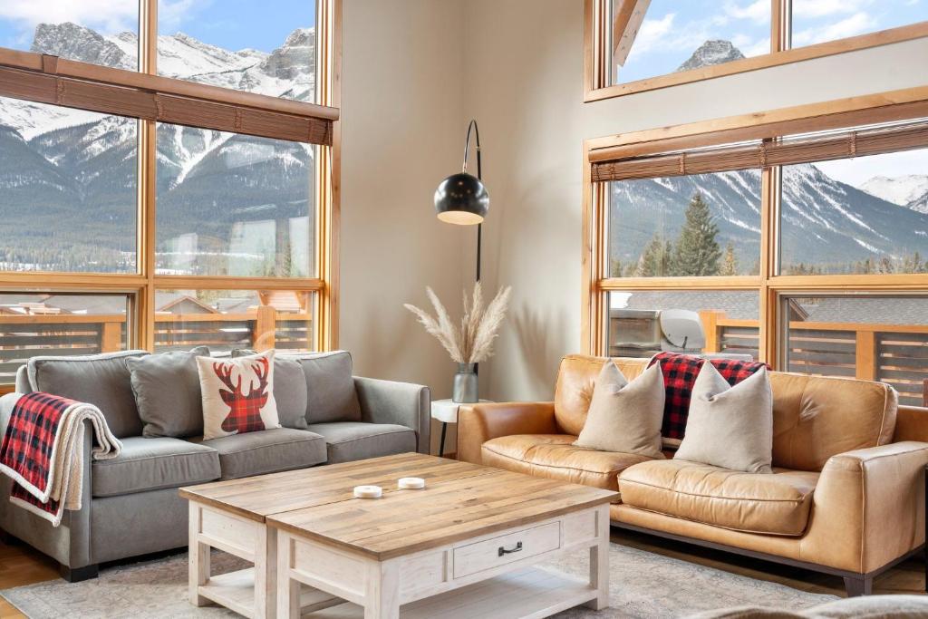 a living room with two couches and a table at Spring Creek Penthouse by Canadian Rockies Vacation Rentals in Canmore