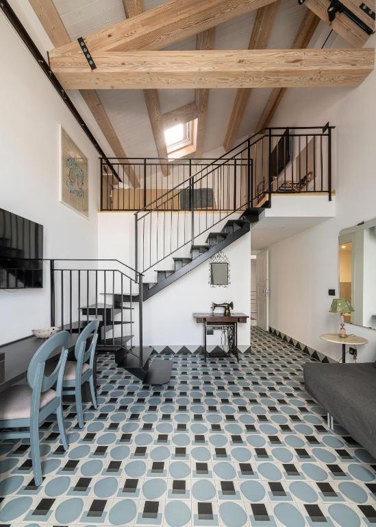 a room with a staircase and a table and chairs at Itaca Porto Loft& Rooms in Milazzo